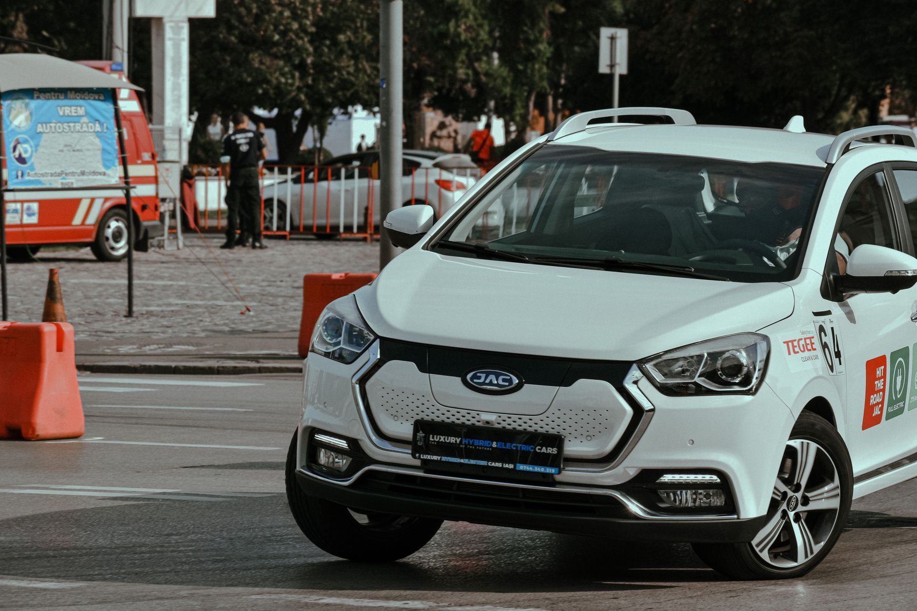 Biały Hyundai Kona Electric szybko pokonuje zakręt w centrum miasta