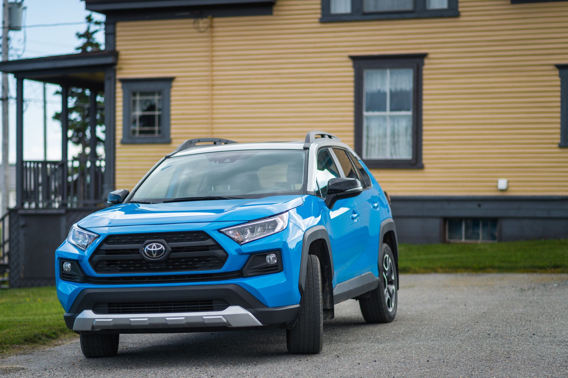 Niebieska Toyota RAV4 zaparkowana przed domem jako przykład konkurencyjnego SUV