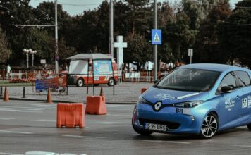 Hyundai Kona Electric w mieście i w trasie – test zużycia energii z perspektywy kierowcy Niebieski Hyundai Kona Electric jedzie po miejskim torze asfaltowym
