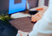Jak zacząć przygodę ze sztuczną inteligencją: praktyczny przewodnik dla początkujących programistów Programista analizuje kod na tablecie w nowoczesnym biurze
