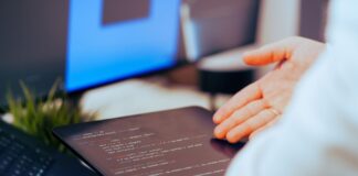 Programista analizuje kod na tablecie w nowoczesnym biurze