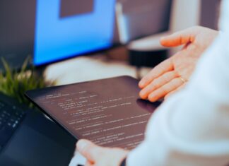 Programista analizuje kod na tablecie w nowoczesnym biurze