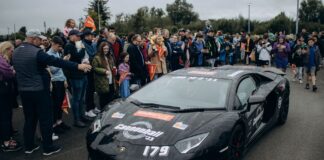 Tłum kibiców podziwia wyścigowe Ferrari podczas emocjonującego eventu