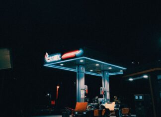Porsche Taycan czy mocne V8 porównanie kosztów eksploatacji prądu i benzyny Nocna stacja benzynowa oświetlona światłami w pustym mieście