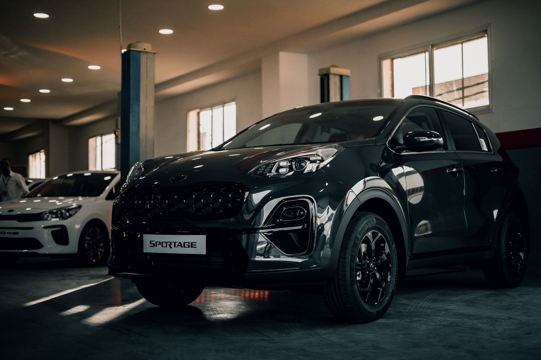 Kia Sportage zaparkowana w stylowym garażu wnętrzowym Kia Sportage zaparkowana w stylowym garażu wnętrzowym