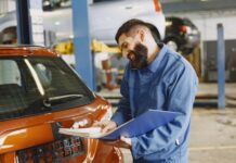 Tanie części i chińska technologia: jak wypada całkowity koszt posiadania SUV-ów Geely po 5 latach Mechanik w warsztacie samochodowym sprawdza auto z dokumentami
