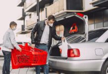 Ojciec z synem pakują zakupy do bagażnika Nissana na parkingu